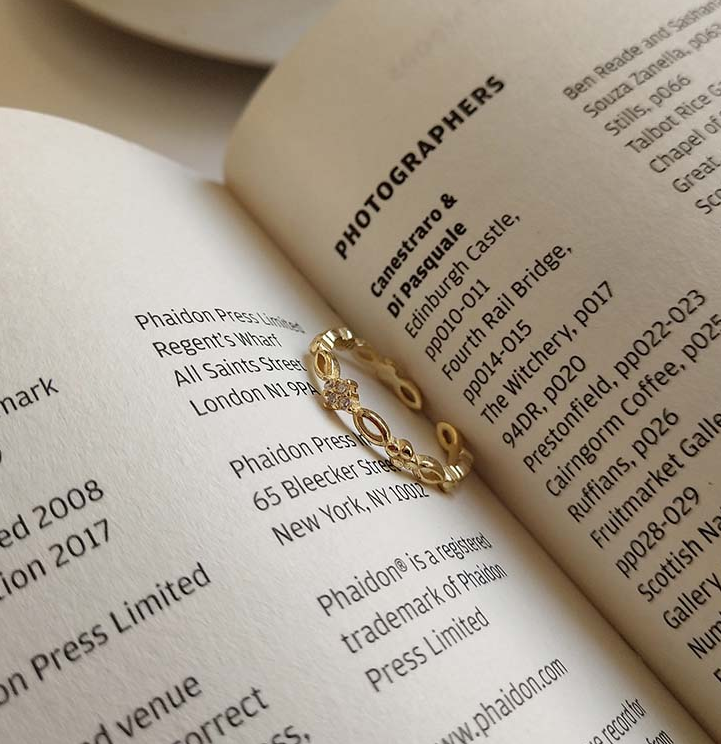 Golden Open Ring resting on the pages of an open book