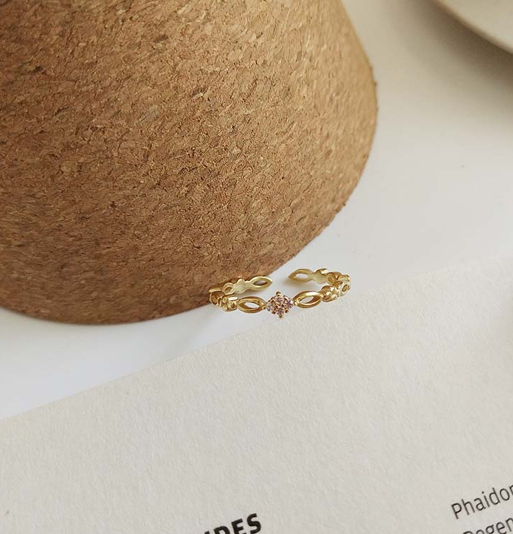 Golden Open Ring photographed from above on cream paper