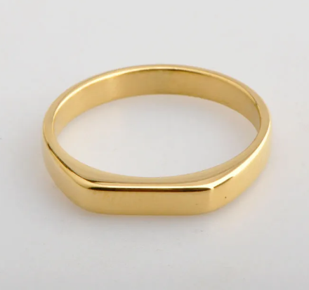 Glow Signet Ring, a gold-plated flat-top signet band, on a soft grey background